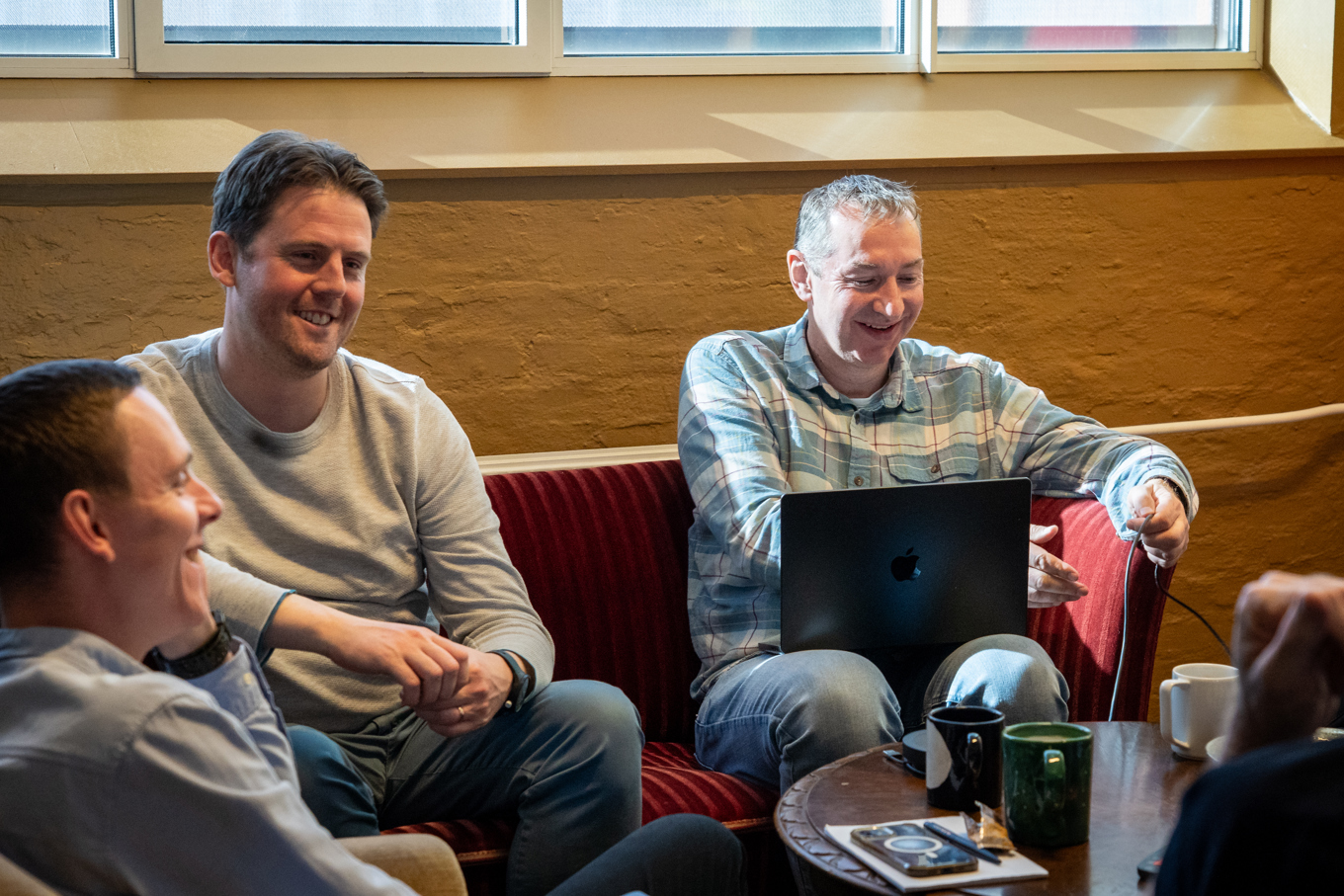 Three people sitting and smiling
